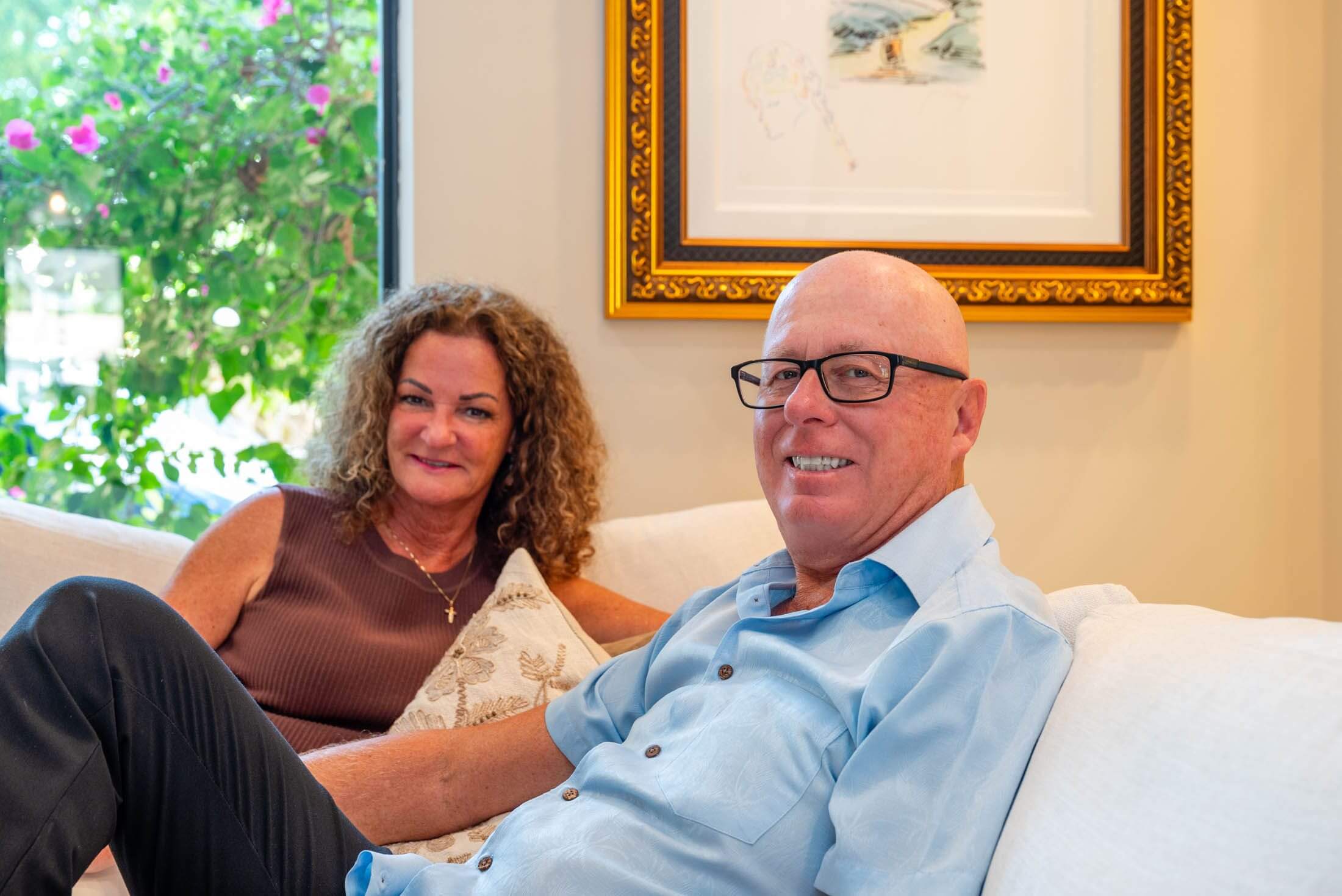 Smiling couple relaxing on bright living room couch
