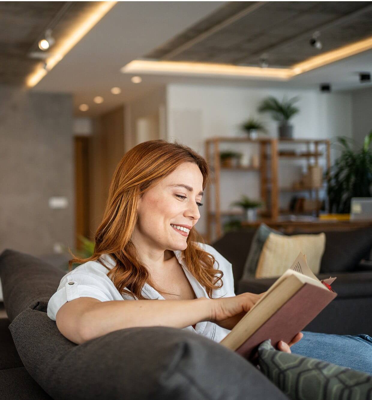 Smiling woman with a book at home