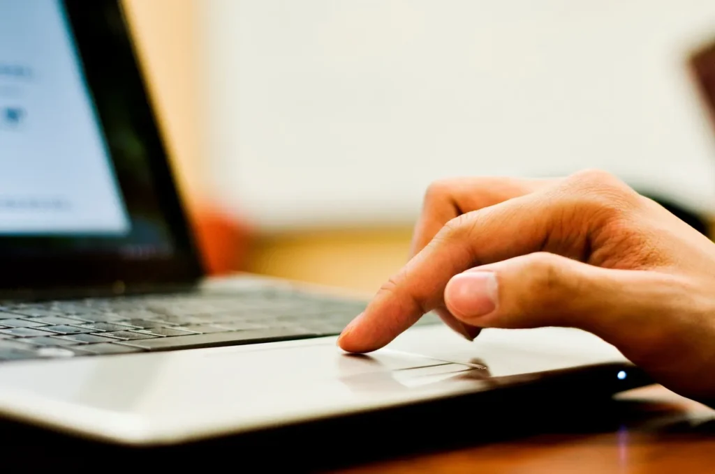 Hand using a laptop touchpad