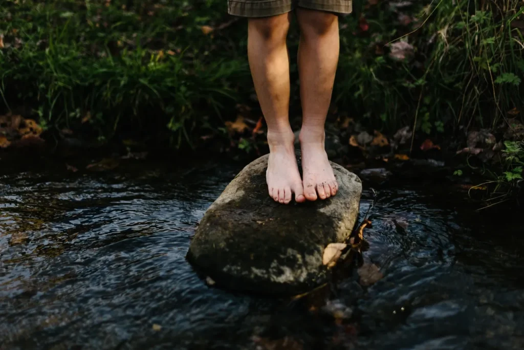 Child's feet on a stream rock
