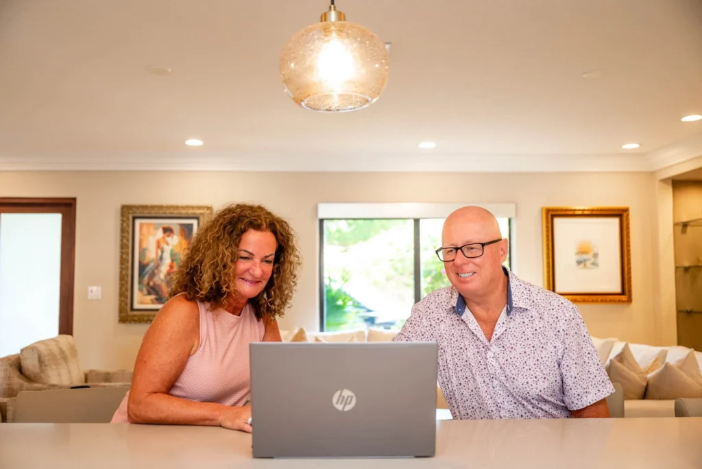 Smiling couple using laptop in cozy living room
