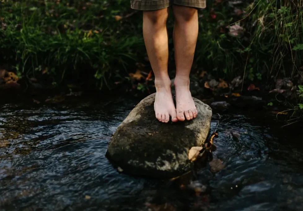 Child's feet on a stream rock