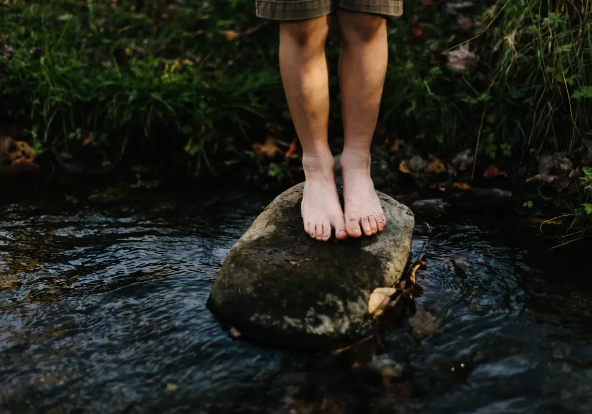 Child's feet on a stream rock