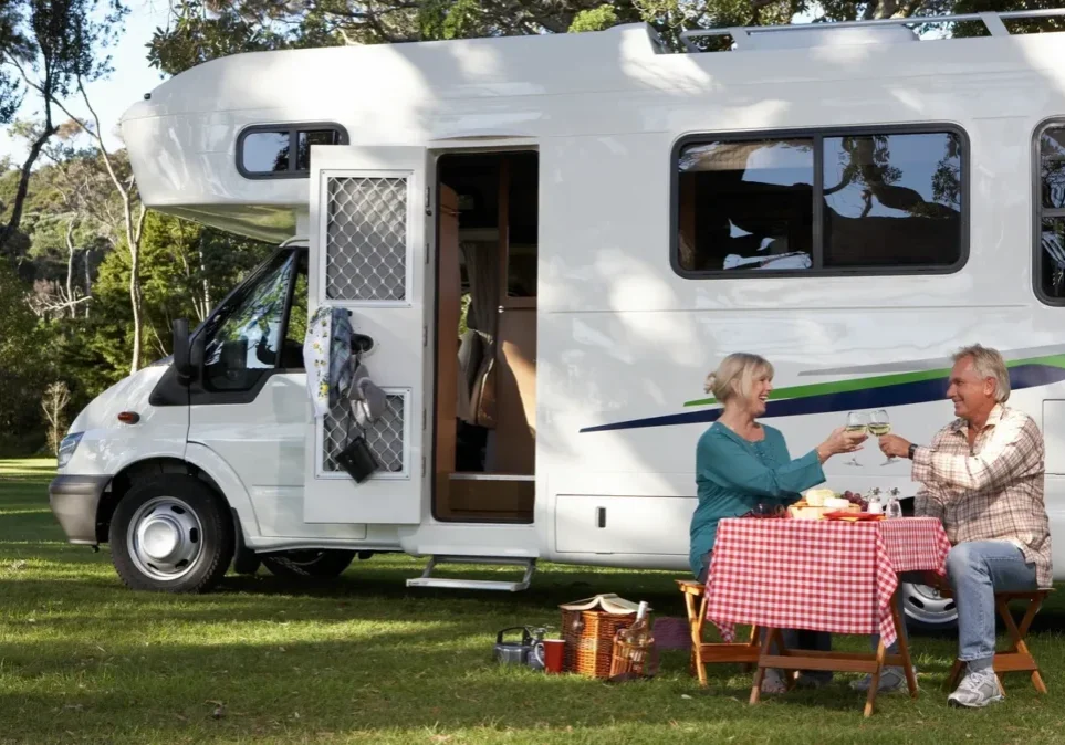 Couple enjoying picnic by motorhome
